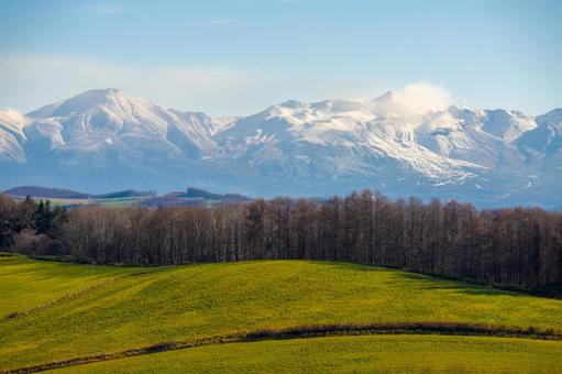 十勝岳連峰と初冬の丘陵地を望む風景写真 北海道,十勝岳,十勝岳連峰の写真素材
