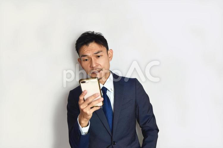 スマホを見るビジネスマン 男性,スマートフォン,ビジネスマンの写真素材