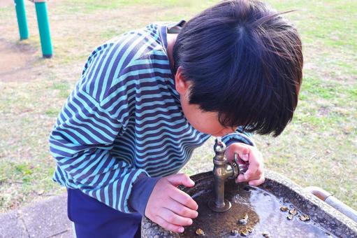 公園の蛇口で「水を美味しそうに飲む少年」 男の子,子供,飲むの写真素材