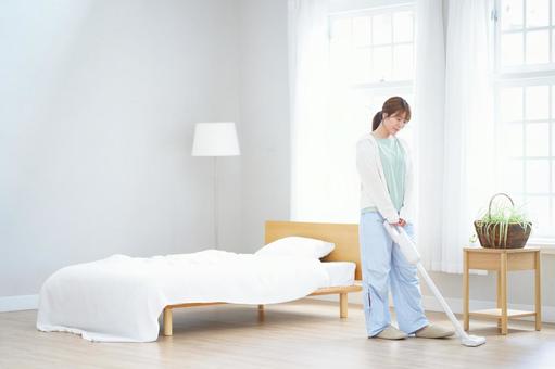 両手で掃除機を持つ女性の写真