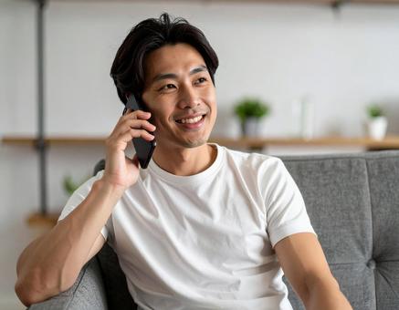 自宅で通話をする男性 自宅で通話をする男性の写真