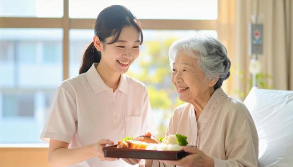 高齢女性と女性介護士の穏やかな食事風景の写真