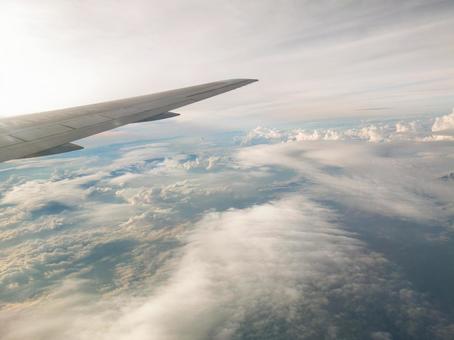 飛行機の窓から見た夕日を浴びた雲海の絶景 飛行機の窓から見た夕日を浴びた雲海の絶景 飛行機,旅客機,翼の写真素材