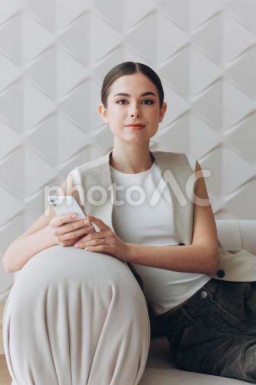 カメラ目線で携帯を持って微笑む女性 女性,人物,インフルエンサーの写真素材
