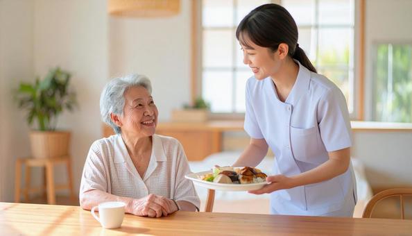 笑顔で食事を運ぶ女性介護士と高齢女性 笑顔で食事を運ぶ女性介護士と高齢女性の写真