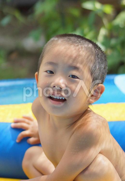 プールで遊ぶ笑顔の男の子 ビニールプール,プール,人物の写真素材