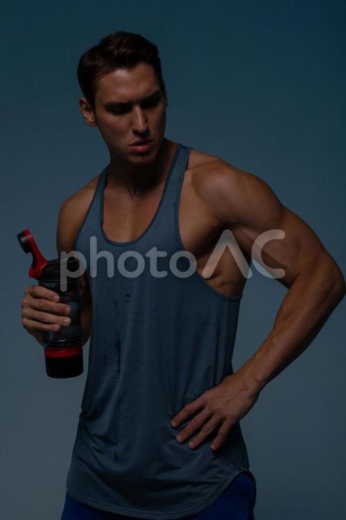 スポーツドリンクのボトルを持つ男性 男性,スポーツドリンク,ボトルの写真素材