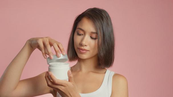 クリームジャーの蓋を開けている女性 クリームジャーの蓋を開けている女性 女性,外国人,アジア人の写真素材