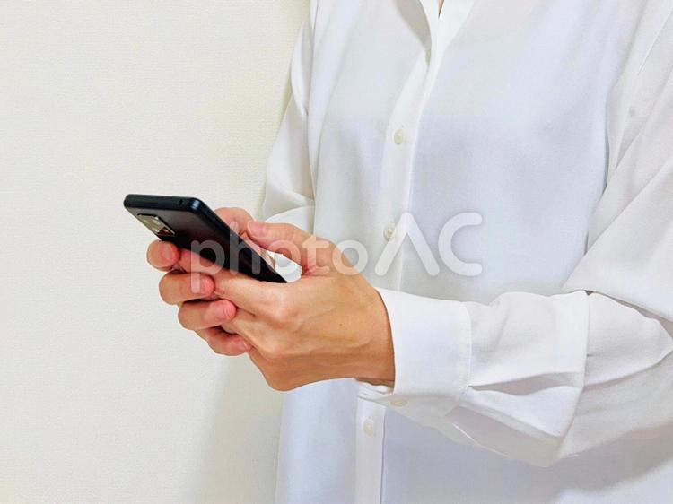 仕事中・スマホ操作中の女性 スマホ,女性,会社員の写真素材
