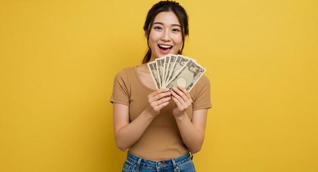 大金を手にして喜ぶ女性 大金を手にして喜ぶ女性の写真