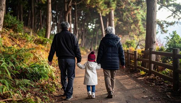 なごやかな雰囲気で森林を歩く家族の後ろ姿 なごやかな雰囲気で森林を歩く家族の後ろ姿の写真