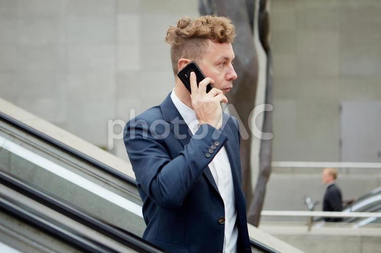 屋外のエスカレーターに乗るビジネスマン6 ビジネスマン,男性,外国人の写真素材