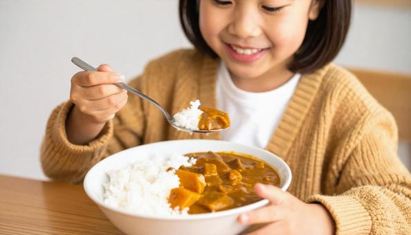 カレーライスをおいしそうに食べている子供 カレーライスをおいしそうに食べている子供の写真