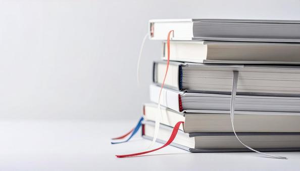 しおりのひもが出ている積みあげられた本の写真