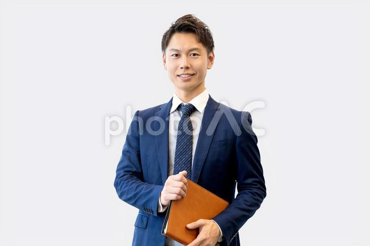 バインダーを持つ笑顔の男性ビジネスマン 男性,ビジネス,ビジネスマンの写真素材