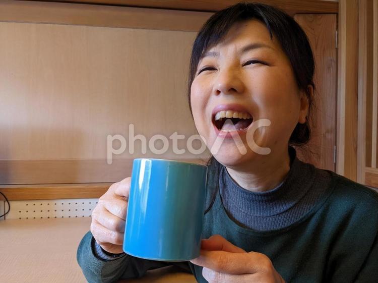 コーヒーを飲みながら大笑いする女性 笑う,笑い,楽しいの写真素材
