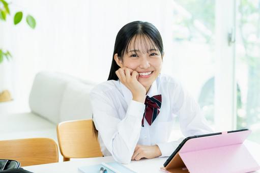 タブレットで勉強する女子高生 タブレットで勉強する女子高生 高校生,笑顔,タブレットの写真素材
