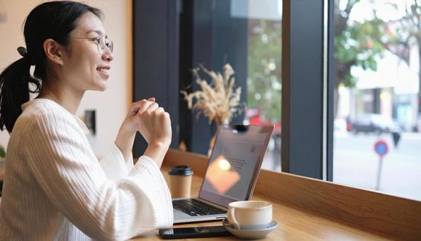 カフェで仕事をするフリーランス女性 カフェで仕事をするフリーランス女性の写真