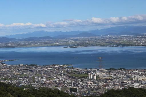 琵琶湖と市街地と山並みと雲と青空の風景 琵琶湖と市街地と山並みと雲と青空の風景 琵琶湖,市街地,山並みの写真素材