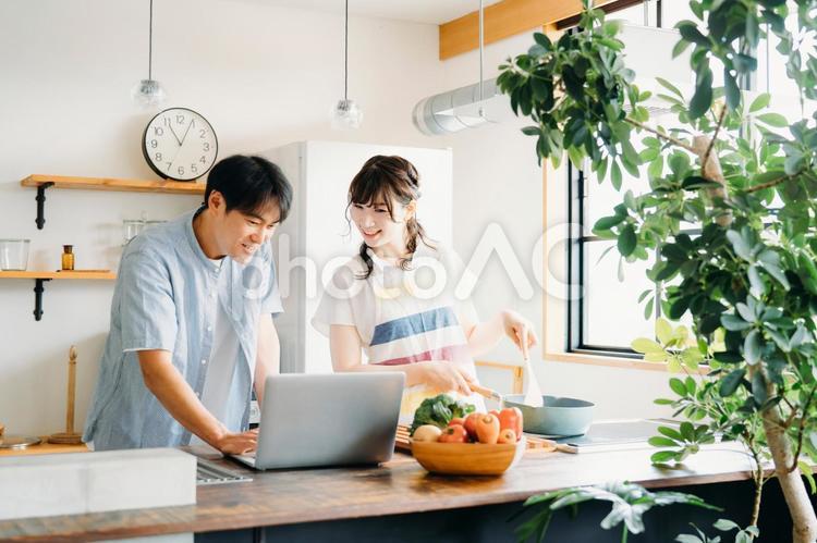 一緒に料理を作る男女（パソコン） 料理,パソコン,レシピの写真素材