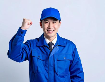 ガッツポーズをする作業着の若い男性 ガッツポーズをする作業着の若い男性の写真