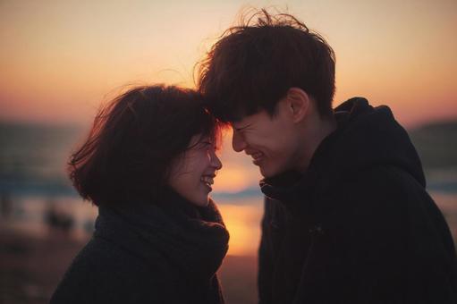 夕日に照らされた若いきらめく恋人たちの写真