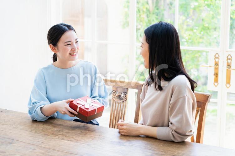 プレゼントを渡す女性 プレゼントを渡す女性 母の日,親子,母親の写真素材