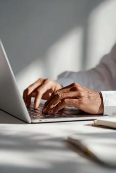 ノートパソコンでタイピングする手元の写真