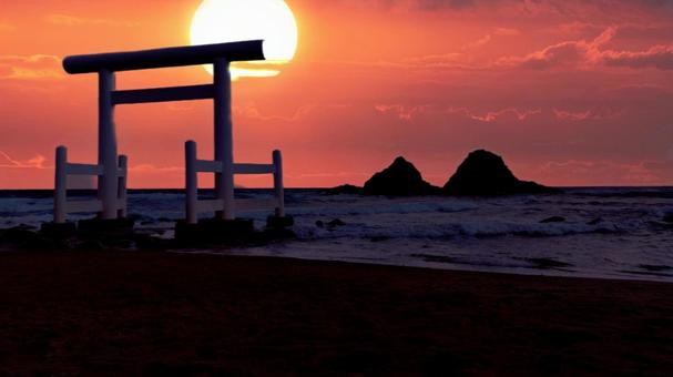 鳥居と海と夕日の写真