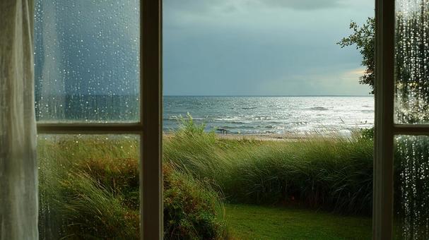 コテージの窓越しの曇り空の海 コテージの窓越しの曇り空の海の写真