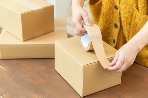 段ボールを梱包する手元 段ボール,ガムテープ,留めるの写真素材