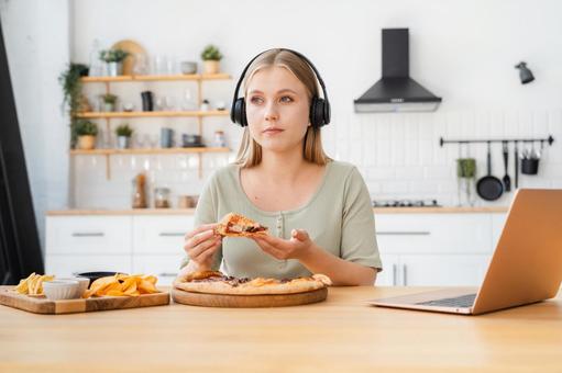 ピザを持っているヘッドフォンの女性 ピザを持っているヘッドフォンの女性 女性,人物,ジャンクフードの写真素材