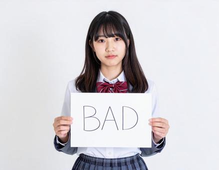 BADと書いたボードをもつ女子生徒 BADと書いたボードをもつ女子生徒の写真