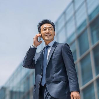 スーツ姿で電話をかける日本人ビジネスマン スーツ姿で電話をかける日本人ビジネスマンの写真