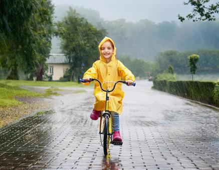 レインコートを着て自転車に乗る男の子 レインコートを着て自転車に乗る男の子の写真