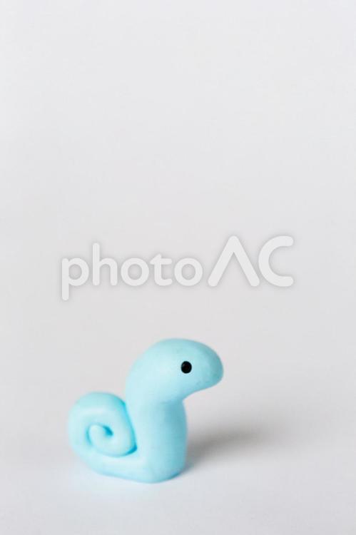 尻尾くるくるでかわいい水色の蛇の縦写真 蛇,クレイアート,動物の写真素材