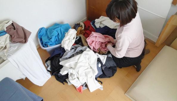 洗濯ものが散乱している女性の狭い部屋 洗濯ものが散乱している女性の狭い部屋の写真