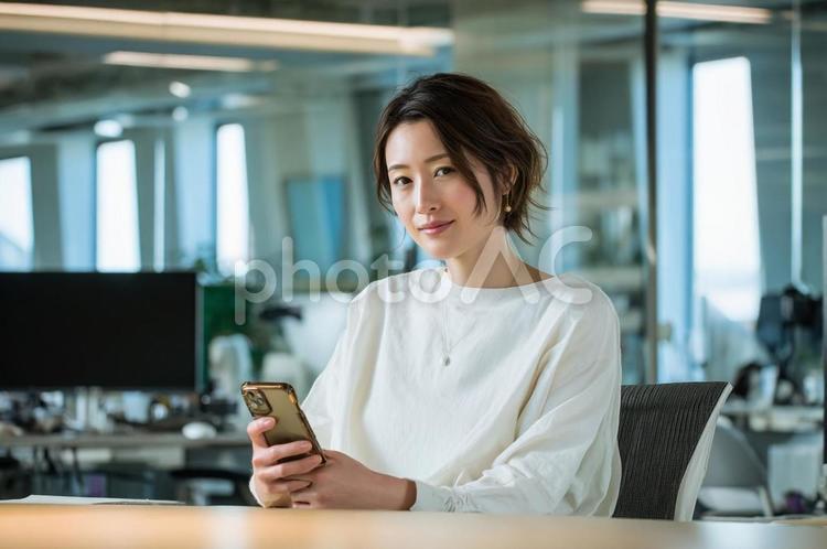 オフィスでスマホを見る女性-4 オフィス,スマホ,女性の写真素材