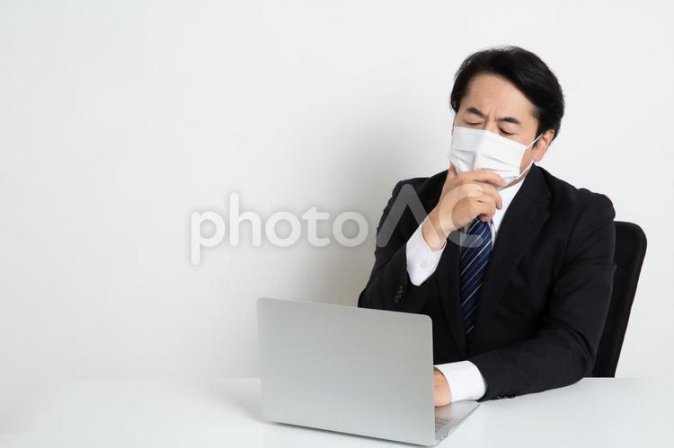マスクをして悩みながら仕事をしている中年のサラリーマン男性（コピースペース） 中年,上司,会社員の写真素材