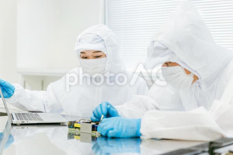 クリーンルームで精密機器を扱う女性 工場,クリーンルーム,製造業の写真素材