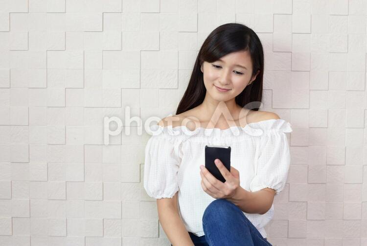 スマートフォンを持つ笑顔の女性 女性,スマートフォン,女の写真素材