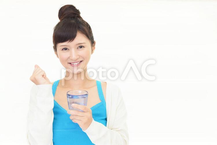お水の入ったグラスを持つ笑顔の女性 女性,女,笑顔の写真素材