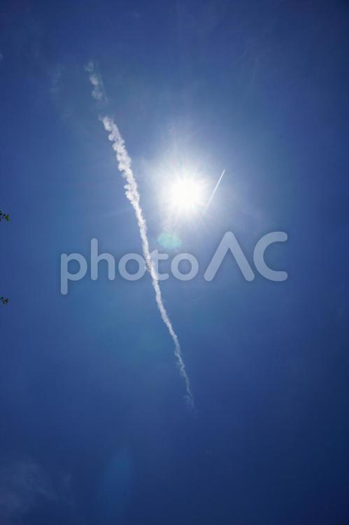 太陽の近くを通る二つの飛行機雲 飛行機雲,太陽,初夏の写真素材