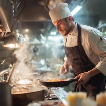 レストランの厨房で料理をするプロのシェフの写真