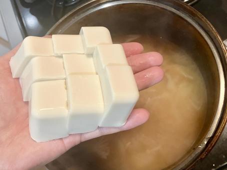 手のひらで切った豆腐を味噌汁へ投入 手のひらで切った豆腐を味噌汁へ投入 味噌汁,豆腐,手の平の写真素材