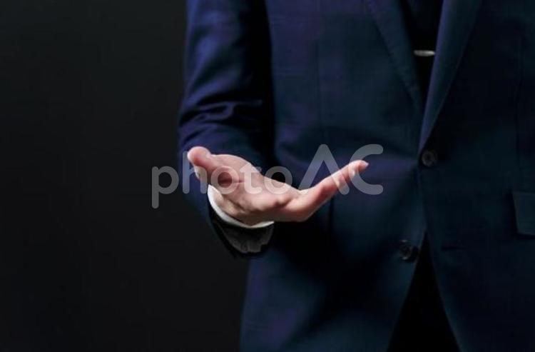  黒背景で手を差し出すビジネスマン 男性,差し出す,手のひらの写真素材