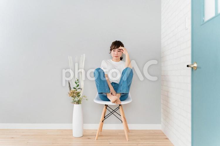 椅子に座りながら悩みを抱えるアジア人女性 悩む,ストレス,考えるの写真素材