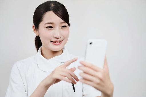 A woman in a white coat operating a smartphone A woman in a white coat operating a smartphone