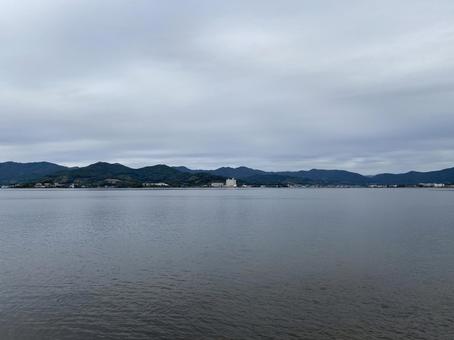 どんよりとした曇り空、湖面は穏やかで静寂の写真