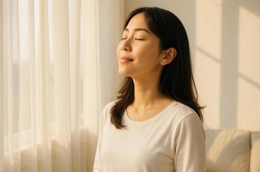 朝日を浴びながら深呼吸する女性 朝日を浴びながら深呼吸する女性の写真